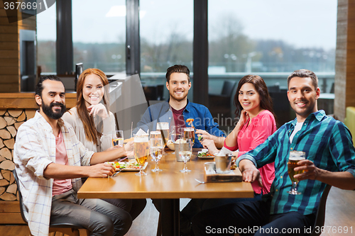 Image of friends dining and drinking beer at restaurant