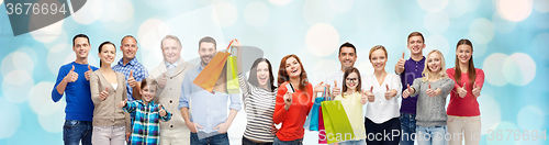 Image of happy people with shopping bags showing thumbs up