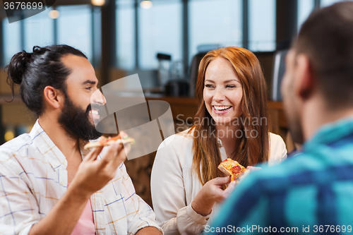 Image of friends eating pizza with beer at restaurant