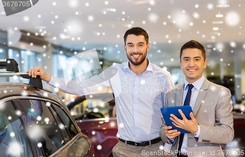 Image of happy man with car dealer in auto show or salon