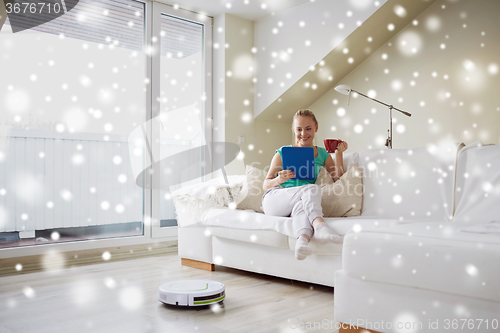 Image of happy woman with tablet pc drinking tea at home