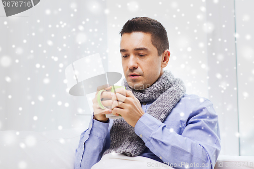 Image of ill man with flu drinking hot tea from cup at home