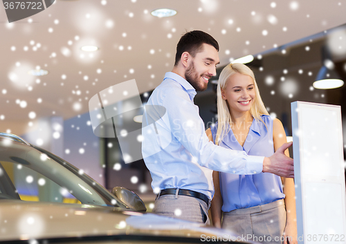 Image of happy couple buying car in auto show or salon