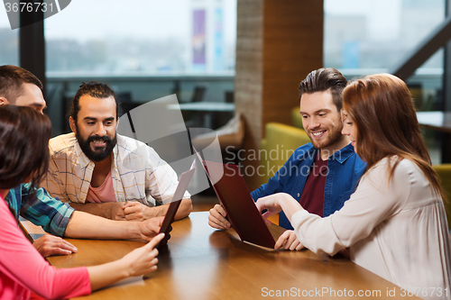 Image of smiling friends discussing menu at restaurant