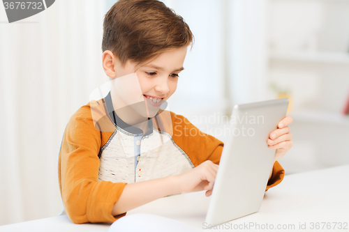 Image of smiling boy with tablet pc computer at home