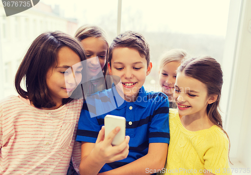 Image of group of school kids taking selfie with smartphone