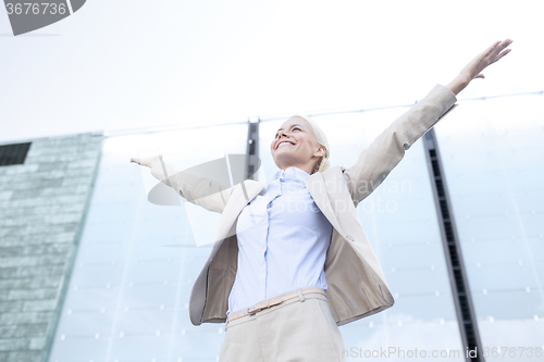 Image of young smiling businesswoman over office building
