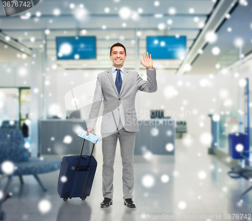 Image of happy businessman in suit with travel bag