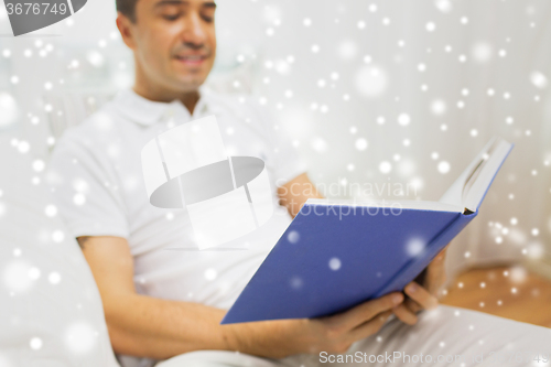 Image of close up of happy man reading book at home