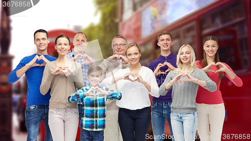 Image of people showing heart hand sign over london city