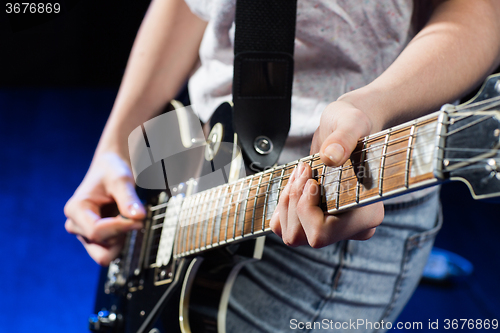 Image of musician playing electric guitar with mediator