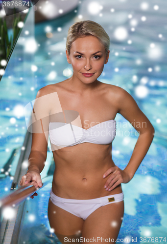 Image of happy woman raising upstairs in swimming pool