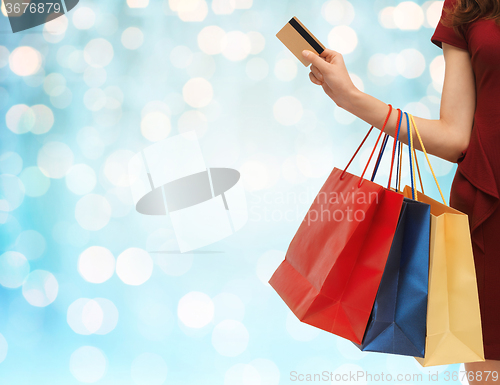 Image of close up of woman with shopping bags and bank card