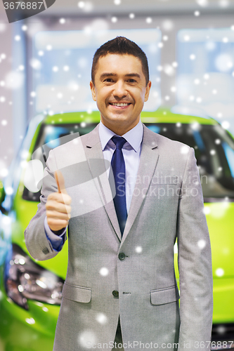 Image of man showing thumbs up at auto show or car salon