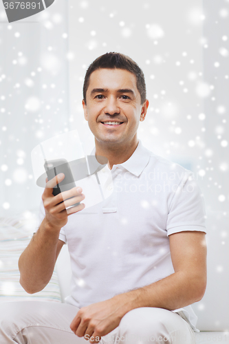 Image of happy man with smartphone at home