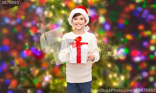 Image of smiling happy boy in santa hat with gift box