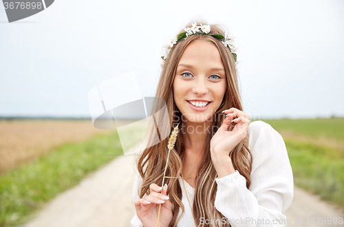 Image of smiling young hippie woman on cereal field