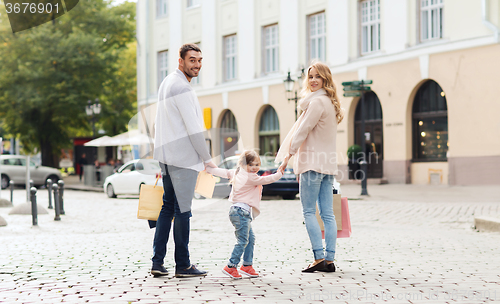 Image of happy family with child and shopping bags in city