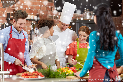 Image of happy friends and chef cook cooking in kitchen