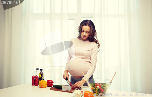 Image of pregnant woman preparing food at home