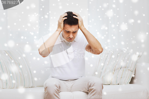 Image of unhappy man suffering from head ache at home