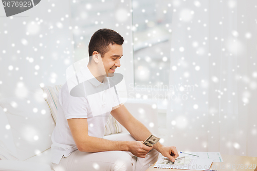 Image of man with papers and calculator at home