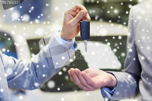 Image of close up of male hands with car key in auto salon