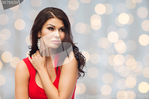 Image of beautiful sexy woman in red dress over lights