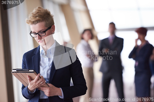 Image of business woman  at office with tablet  in front  as team leader