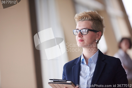 Image of business woman  at office with tablet  in front  as team leader