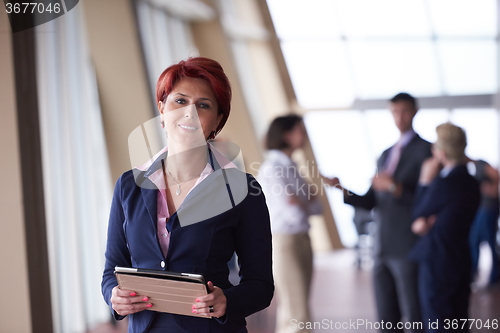 Image of business woman  at office with tablet  in front  as team leader