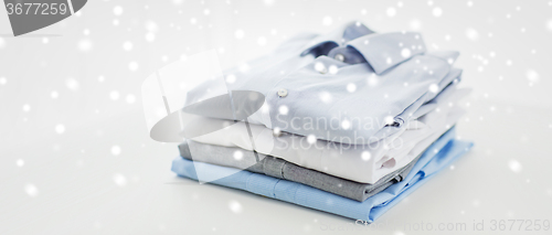 Image of close up of ironed and folded shirts on table