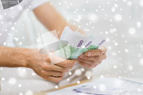 Image of close up of man hands counting money at home