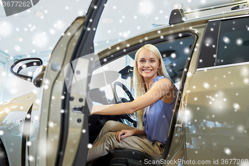 Image of happy woman inside car in auto show or salon