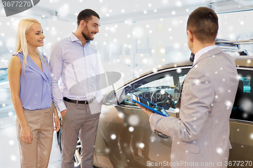 Image of happy couple with car dealer in auto show or salon