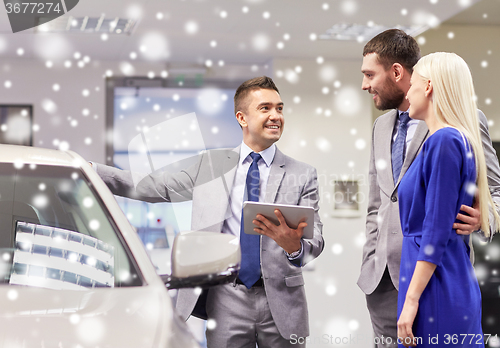 Image of happy couple with car dealer in auto show or salon