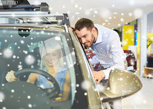 Image of happy couple buying car in auto show or salon