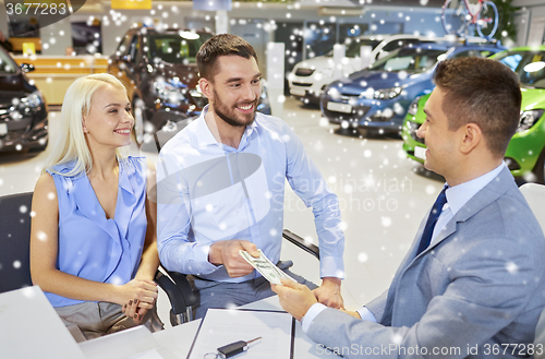 Image of happy couple with money buying car from dealer