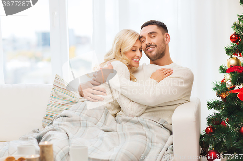 Image of happy couple at home with christmas tree