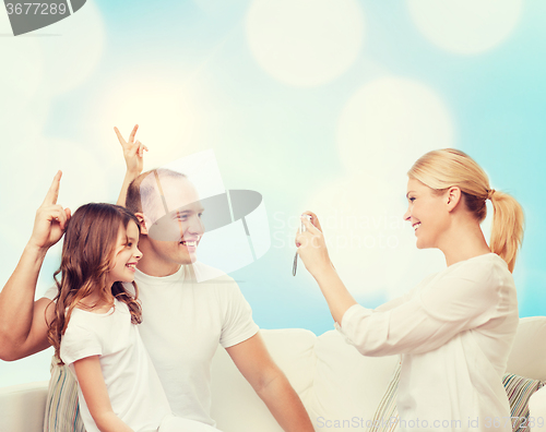 Image of happy family with camera at home