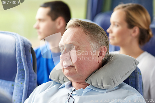 Image of senior man sleeping in travel bus with neck pillow
