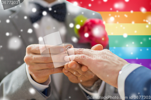 Image of close up of male gay couple hands and wedding ring