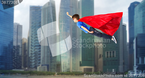 Image of boy in red superhero cape and mask flying on air