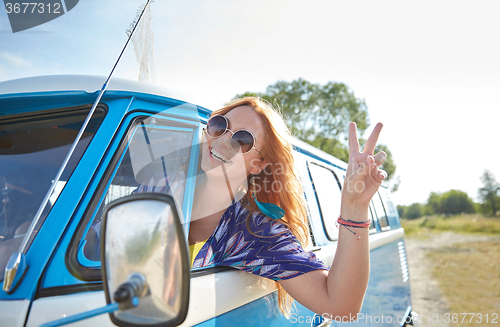 Image of smiling young hippie woman driving minivan car
