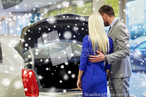 Image of happy couple choosing car in auto show or salon