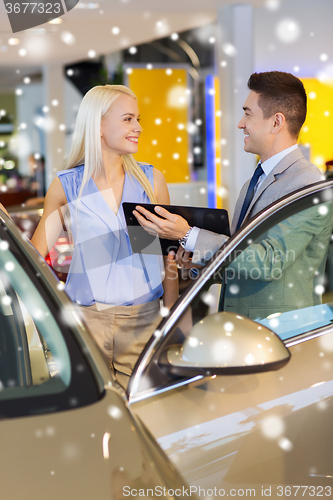 Image of happy woman with car dealer in auto show or salon