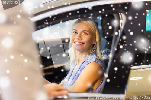 Image of happy woman with car dealer in auto show or salon