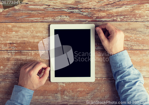 Image of close up of male hands to tablet pc on table
