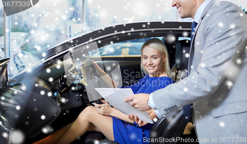 Image of happy woman with car dealer in auto show or salon