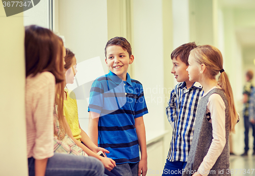 Image of group of smiling school kids talking in corridor